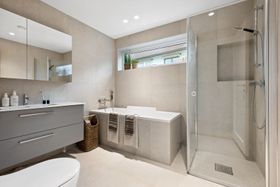 Bide av flislagt bad og badekar med fliser i vinduskarmen