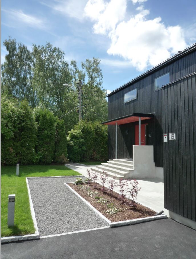 Bilde av gruslagt vei fra garasjen inn til huset. Belysning langs grusveien.