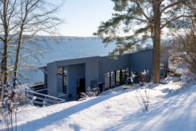 Bilde av husets fasade med fjorden i bakgrunnen