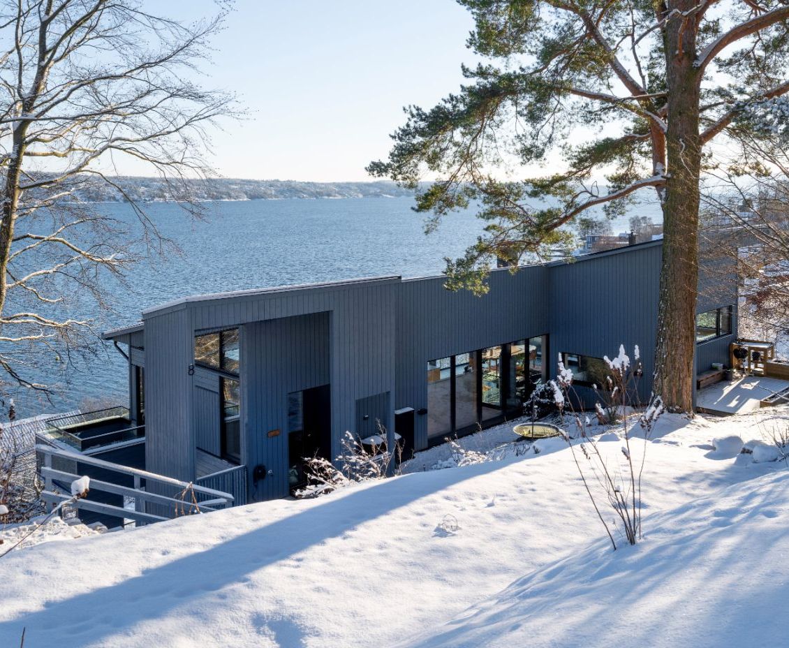 Bilde av husets fasade med fjorden i bakgrunnen