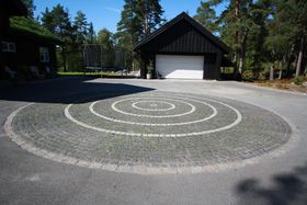 Brosteinsirkel midt på asfaktert gårsdplass