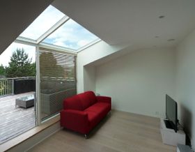 Bilde av TV stue med store vinduer og terrasseutgang