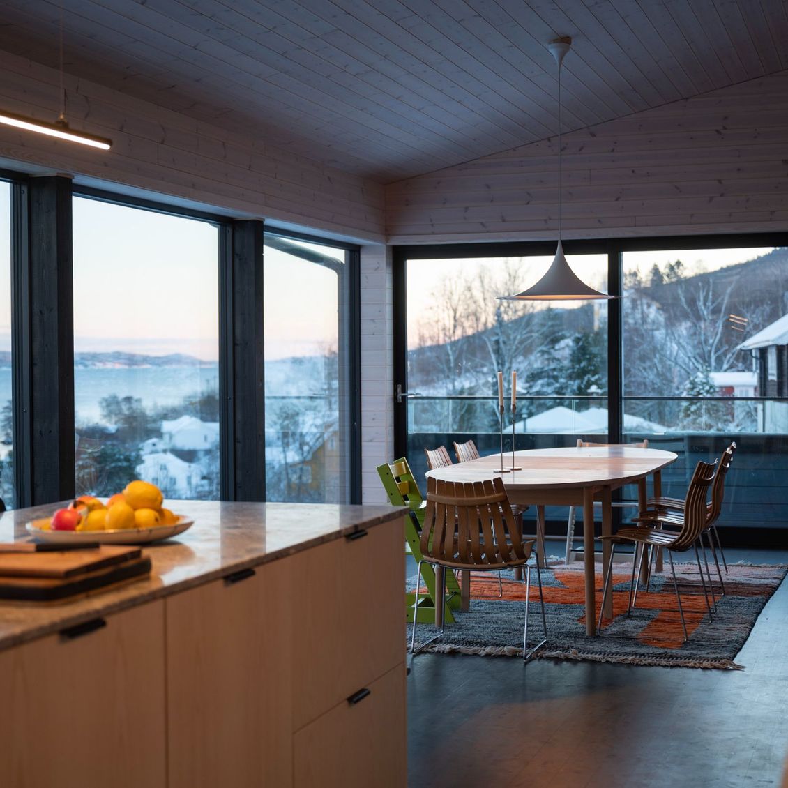 Bilde av kjøkken og spisestue med utsikten over fjorden i bakgrunnen